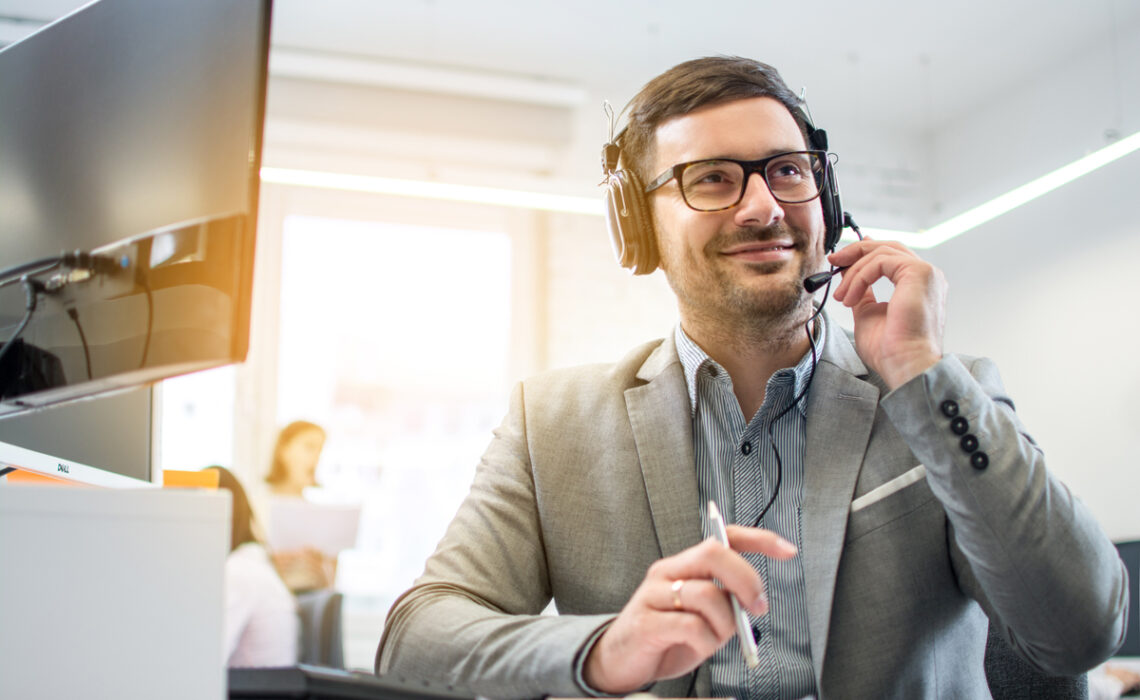 Customer service operator man with headset listening to a client with attention while working in call center